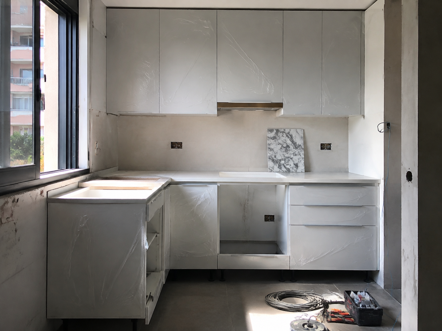 Cocina en reforma con muebles instalados y herramientas de obra