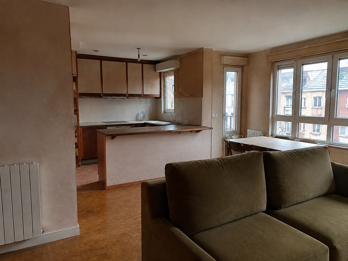 Salón y cocina original de un piso antes de su reforma en el Centro de Oviedo